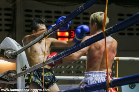 Max fending off opponent at Patong Boxing Stadium